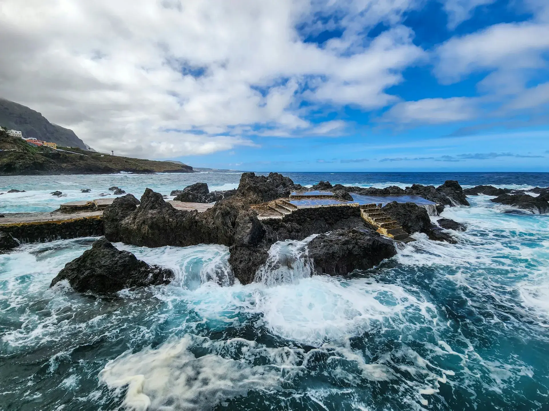 Piscina natural excavada en la lava de la costa norte de Tenerife, con el mar de fondo desbordando sus muros