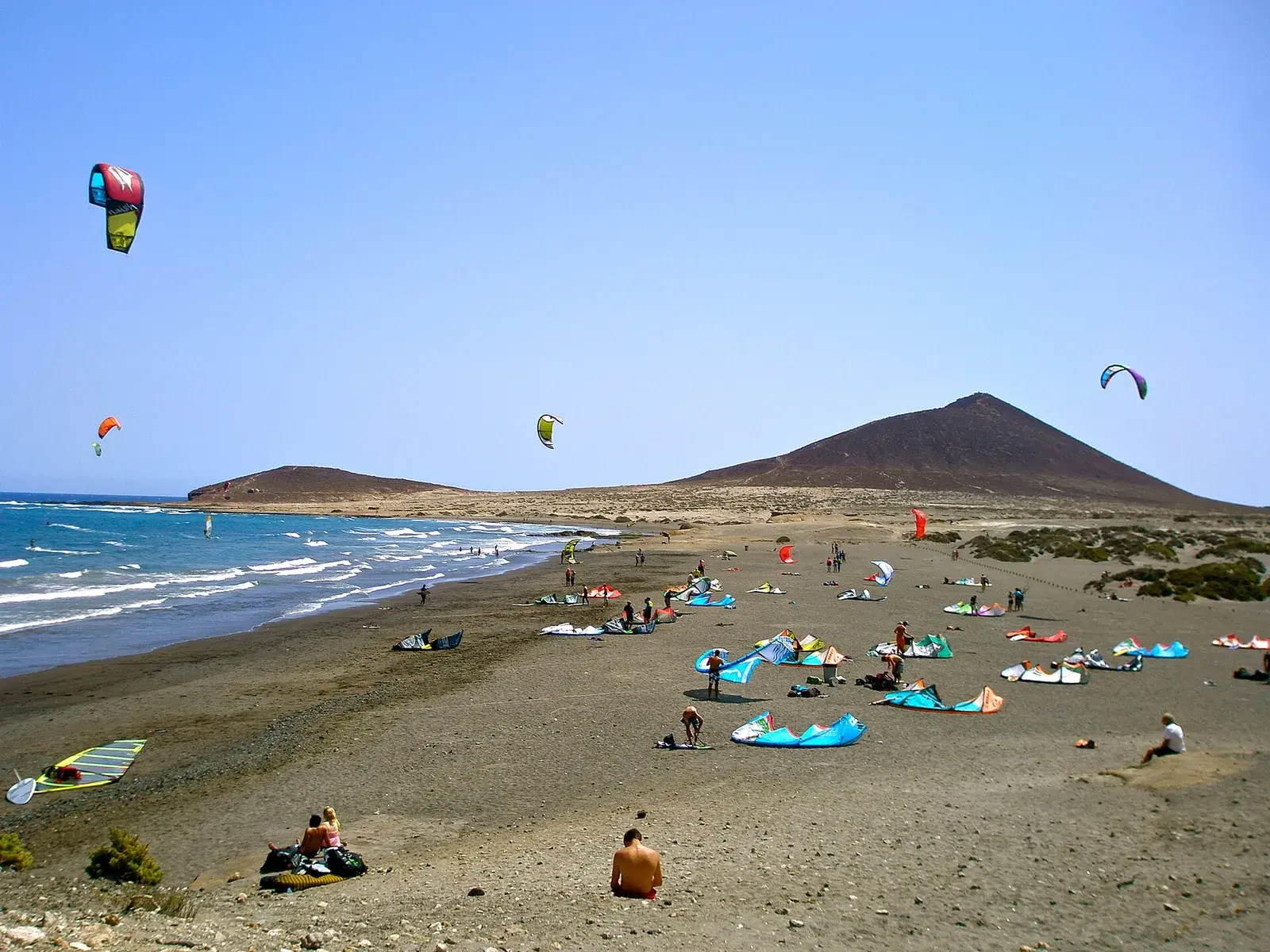 Cometas de kitesurf sobre la playa de El Médano, con la Montaña Roja al fondo