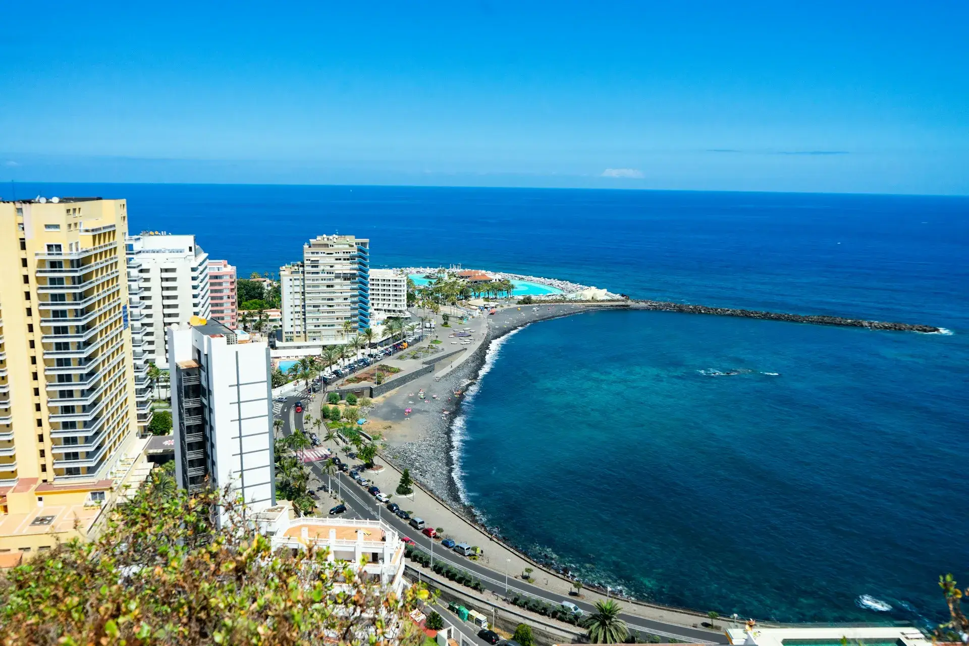 Costa de Puerto de la Cruz con su playa de arena negra en curva, el paseo y los hoteles junto al mar