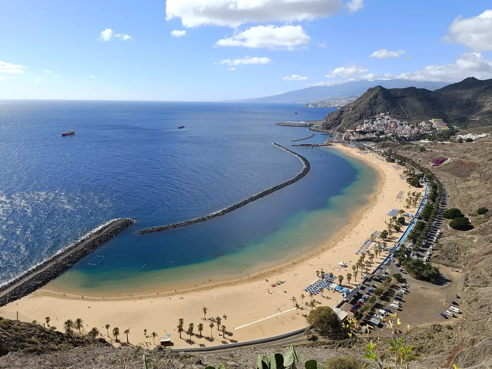 Vista aérea de la playa de Las Teresitas, con su arena dorada, los espigones y San Andrés al fondo