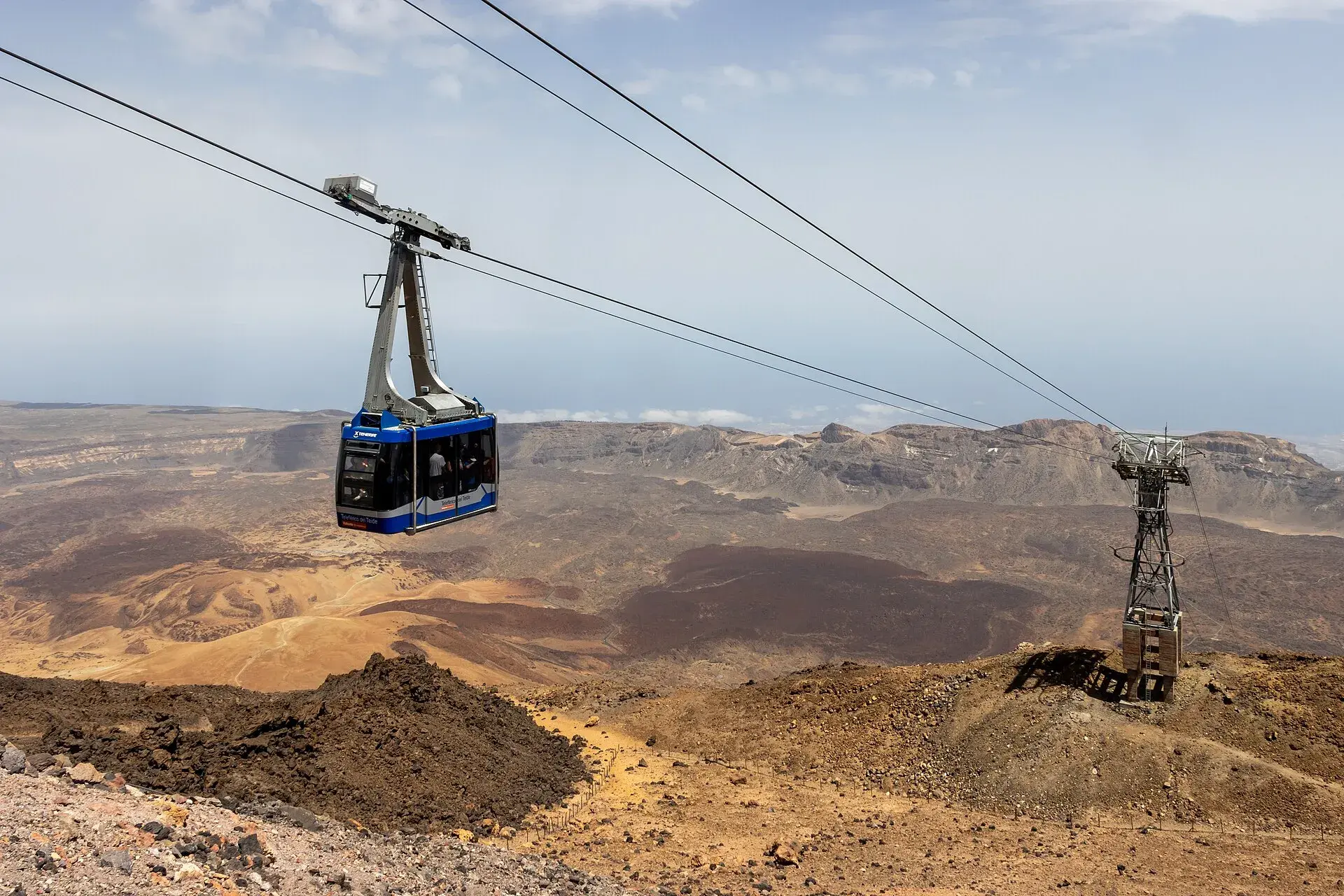 Cabina del teleférico del Teide suspendida sobre las coladas de lava con la caldera de Las Cañadas al fondo