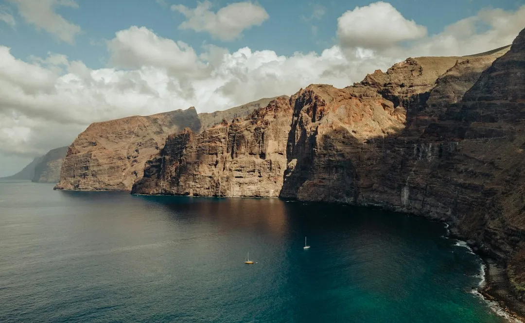 The Los Gigantes cliffs seen from the sea, with two sailing boats below