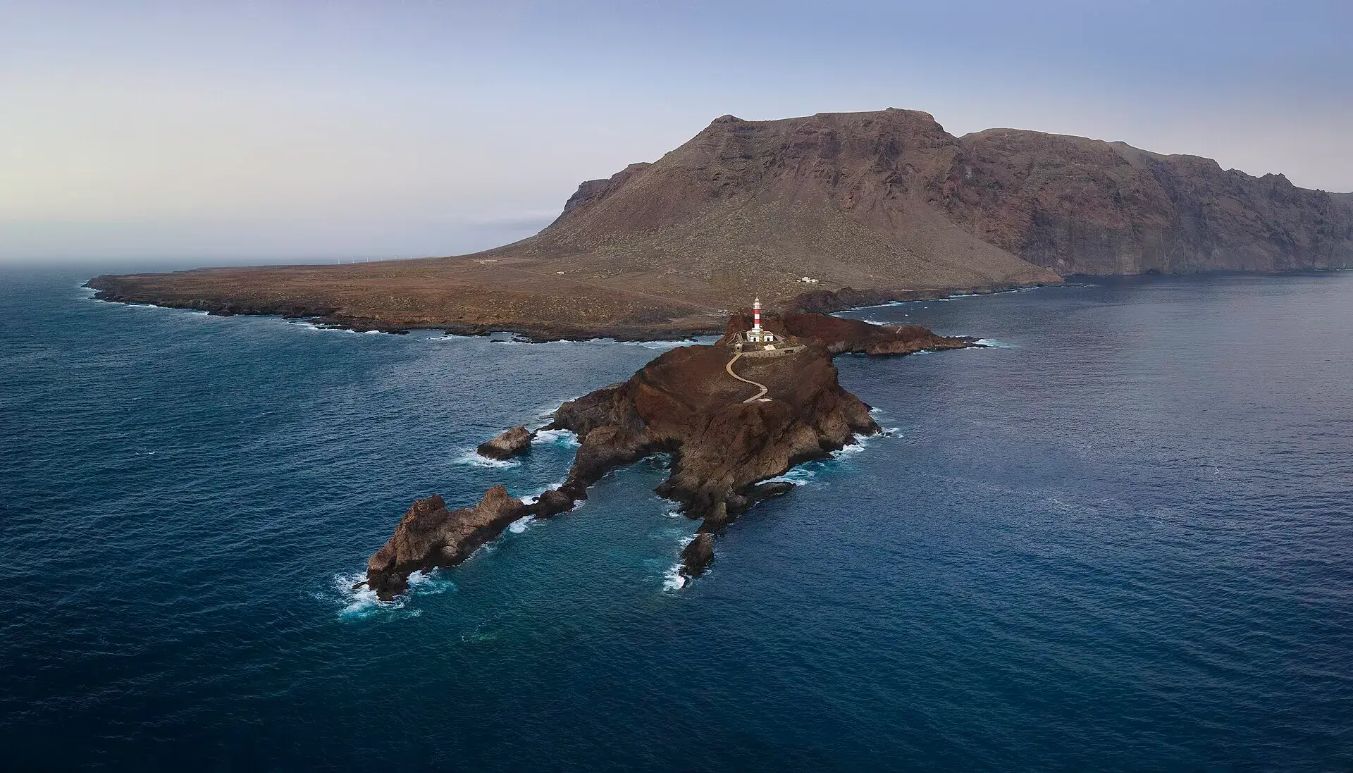 Vista aérea de Punta de Teno con su faro sobre la lengua de lava y el macizo de Teno al fondo